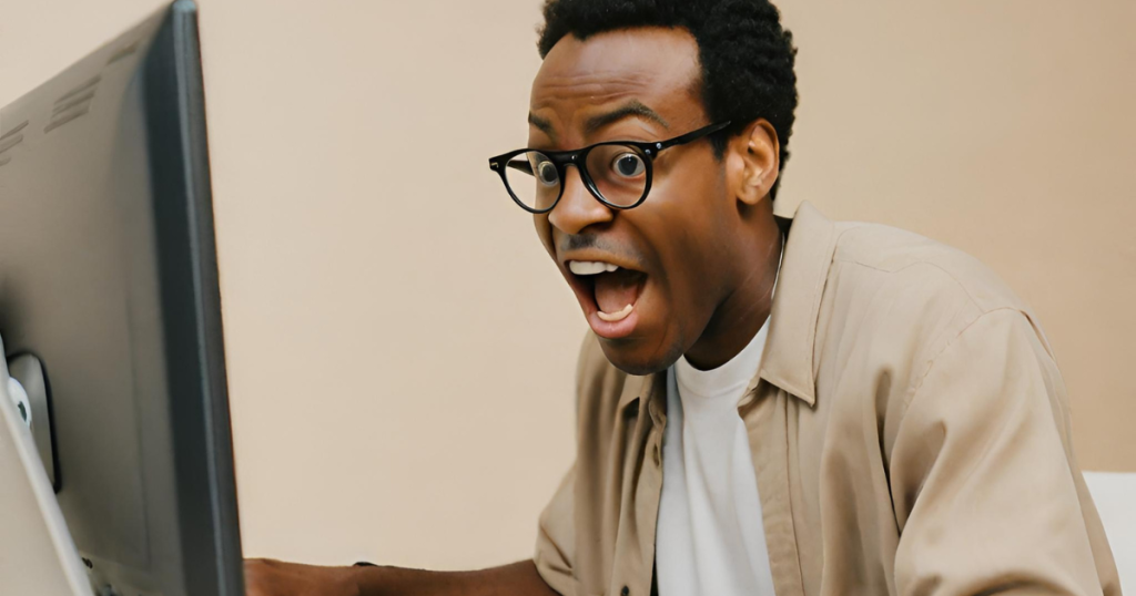 A black man excitedly searching the internet from his computer